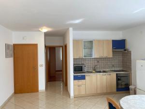 - une cuisine avec des placards en bois et un four micro-ondes dans l'établissement Apartments Malinska - apartment 3, à Malinska