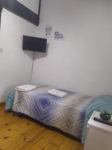 Prío的住宿－Casa El Lavadero Prio，卧室配有一张挂有墙上标志的床