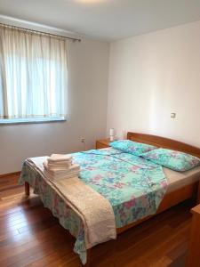- une chambre avec un lit et une couette à fleurs dans l'établissement Apartments Malinska - apartment 3, à Malinska