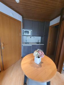 una pequeña cocina con una mesa de madera con flores. en VIELHA XVI, en Vielha