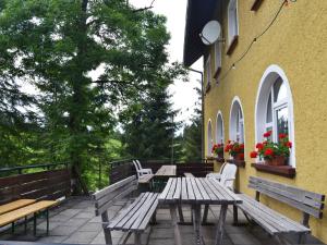 eine Terrasse mit Bänken und Tischen auf einem Gebäude in der Unterkunft Kraichgauer Haus in Oberreute