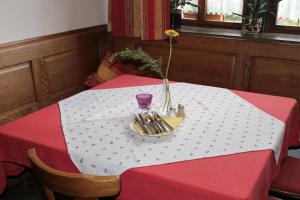 uma mesa vermelha e branca com um prato com um vaso sobre ela em Gasthof Butz em Rothenburg ob der Tauber