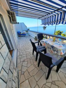 a patio with a table and chairs and the ocean at Apartments Marijana in Zavalatica