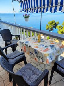 a table and chairs on a balcony with the ocean at Apartments Marijana in Zavalatica