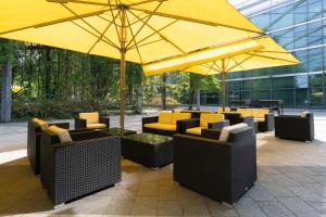a yellow umbrella and some chairs and tables at Seminaris CampusHotel Berlin in Berlin