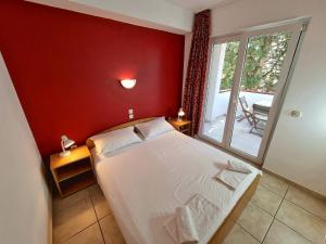 Un dormitorio con una cama grande con una pared roja. en Apartments Ostrea - Mimoza, en Novalja