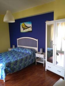 una camera con letto e parete blu di Domus Musia a Milazzo