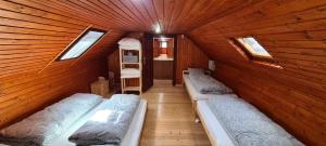 a room with three beds in a wooden cabin at Dukla Ranč in Nižný Komárnik