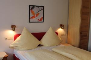 a bedroom with a bed with two pillows on it at Gasthof Butz in Rothenburg ob der Tauber