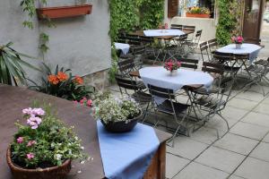 a patio with tables and chairs with flowers on them at Gasthof Butz in Rothenburg ob der Tauber