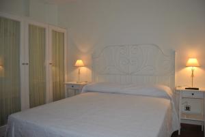 Suesa的住宿－Posada de Suesa，卧室配有白色的床和两张台灯。