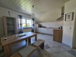 a large kitchen with a wooden table and a table sidx sidx sidx at Ferienwohnung Toni mit Balkon und Garten in Pemfling