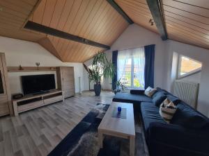 a living room with a blue couch and a table at Ferienwohnung Toni mit Balkon und Garten in Pemfling