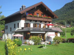 Una casa grande con un balcón con flores. en Appartement Scheibling, en St. Wolfgang
