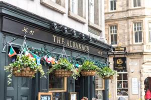 a restaurant with potted plants in front of it at Royal Mile & Arthur's Seat Apt with Private Parking in Edinburgh