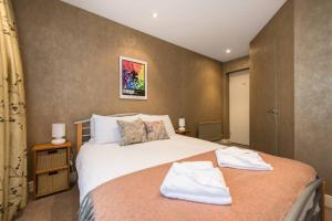 um quarto com uma cama grande e toalhas em Royal Mile & Arthur's Seat Apt with Private Parking em Edinburgo
