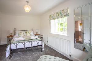 a bedroom with a bed and a window at Laundry Cottage: Drumlanrig Castle in Thornhill