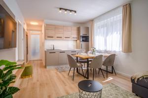 kuchnia i jadalnia ze stołem i krzesłami w obiekcie MF Batthyány Premium Residence w Siófoku