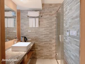 a bathroom with a white sink and a shower at Seeing Inn in Taitung City