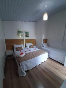 a bedroom with a large bed with red flowers on it at Flat Pico Vulcanico in Fernando de Noronha