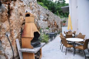 an outdoor patio with a fireplace and tables and chairs at Haus Zora Ferienwohnung 7 in Mošćenice