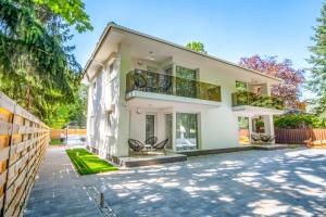 ein großes weißes Haus mit einer Terrasse in der Unterkunft MF Batthyány Premium Residence in Siófok