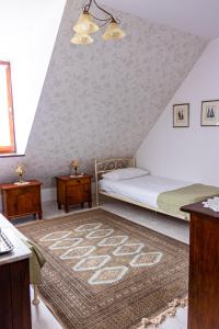 a bedroom with a bed and two tables and a rug at Karczma Rzym in Wrocław