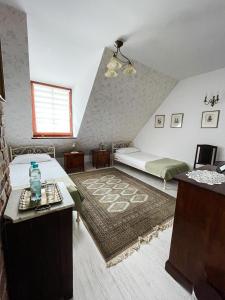 a attic room with a bed and a table and a couch at Karczma Rzym in Wrocław