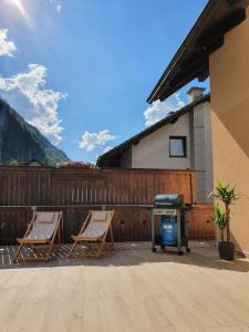 two chairs and a grill on a patio at Apartma Kreda in Mojstrana