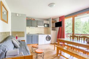 ein Wohnzimmer mit einem Sofa und einem Tisch in der Unterkunft L'Oural in Les Orres