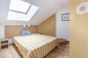 ein Schlafzimmer mit einem Bett und einem Dachfenster in der Unterkunft L'Oural in Les Orres