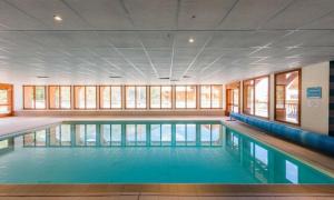 ein großer Pool mit blauem Wasser in einem Gebäude in der Unterkunft L'Oural in Les Orres