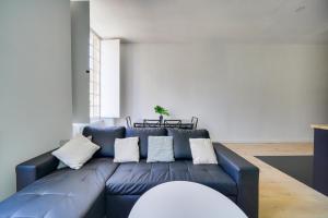 - un canapé bleu avec des oreillers blancs dans le salon dans l'établissement Nice apartment for 2 in historical center, à Bordeaux