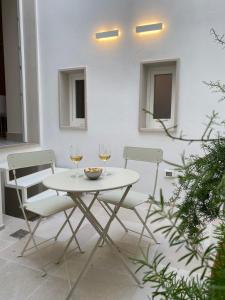 a white table with two glasses of wine at Dimore Garibaldi - Borgo di Puglia Houses & Lands in Monopoli +13 photos