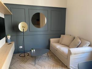 a living room with a couch and a round mirror at Dimore Garibaldi - Borgo di Puglia Houses & Lands in Monopoli