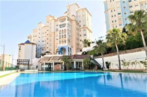 a large swimming pool in front of a large building at #PrettyPenthouseEstepona in Estepona