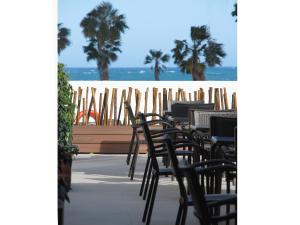 
a beach area with chairs, tables and umbrellas at Hotel Santamarta in Cullera
