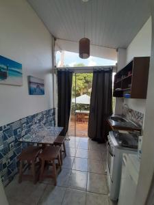 uma cozinha com mesa e cadeiras e um pátio em Flat Pico Vulcanico em Fernando de Noronha