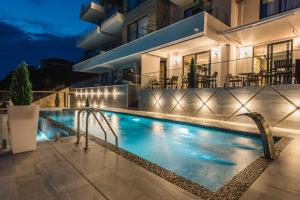 a villa with a swimming pool at night at Dollaku Seafront Apartments in Bar