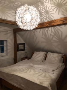 a bedroom with a white bed with a chandelier at Lampenhäuschen in Dhronecken