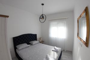 een slaapkamer met een bed en een spiegel bij Villa Lila in Mostar