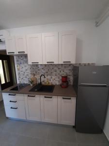 a kitchen with white cabinets and a black refrigerator at Apartment Sandra in Rabac +44 photos