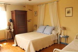 1 dormitorio con 1 cama con almohadas azules en Maison d'Hôtes Las Baillargues de Haut, en Mouchan