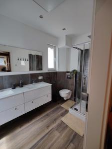 a bathroom with a toilet and a sink and a shower at Tolles schönes Ferienhaus mit großer Grillterrasse für 12 Personen im Harz in Sankt Andreasberg