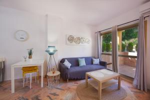 un soggiorno con divano blu e tavolo di Varios apartamentos Romana Playa Elviria a Marbella
