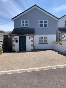 Uma casa branca com uma entrada à frente. em Buckfield Roost 3 bedroom Newlyn, free parking for 2 cars em Newlyn