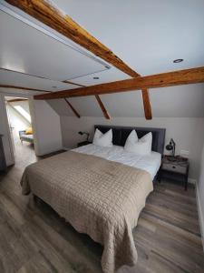um quarto com uma cama grande num sótão em Neues schönes Ferienhaus mit großer Grillterrasse für 12 Personen im Harz em Sankt Andreasberg