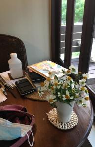 a table with a vase with flowers on it at Jasmine & Tea House in Mae Nam