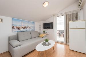 ein Wohnzimmer mit Sofa und Tisch in der Unterkunft Ilia sea view apartment in Novalja