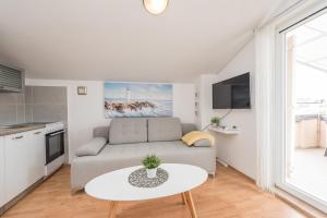 ein Wohnzimmer mit Sofa und Tisch in der Unterkunft Ilia sea view apartment in Novalja